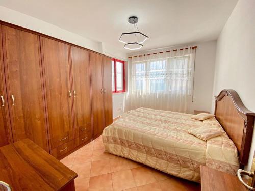 1 dormitorio con 1 cama y armarios de madera en Durres Apartament, en Durrës