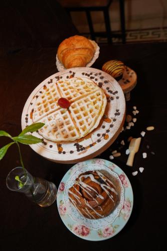 a table with two plates of food and a waffle at BELVA huis in Bogor