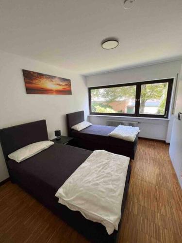 a bedroom with two beds and a window at Sunset Dreams Apartment in Bühl