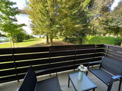 a patio with two chairs and a table with a vase of flowers at Sunset Dreams Apartment in Bühl