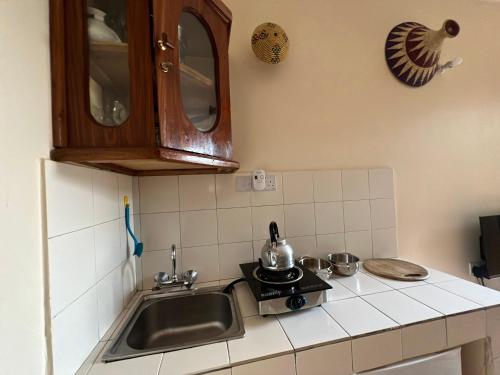 uma pequena cozinha com um lavatório e um fogão em Triton Apartments em Pwani Mchangani