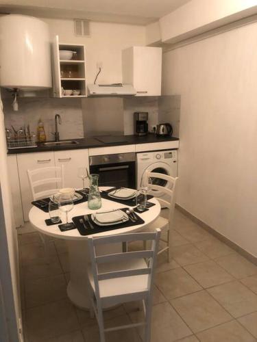 uma pequena cozinha com mesa e cadeiras em Superbe appartement meublé refait à neuf em Montélimar