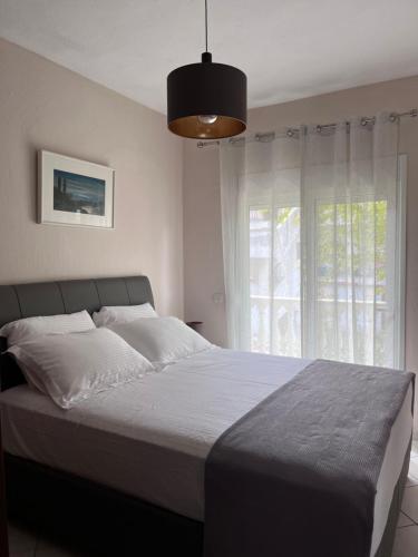 a bedroom with a large bed with a large window at Καλλιθεα in Kallithea Halkidikis