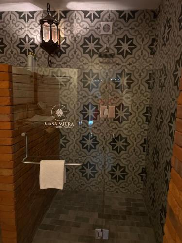a bathroom with a shower and a towel on a wall at Casa Miura Hotel Boutique in Ajijic