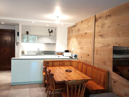 - une cuisine avec une table en bois et un mur en bois dans l'établissement Duplex rénové 3 pièces avec jardin, parking et animaux admis à Chamonix - FR-1-517-25, à Chamonix-Mont-Blanc
