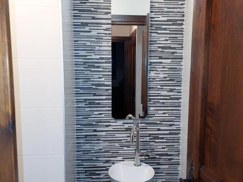 une salle de bain avec un lavabo et un miroir dans l'établissement Duplex rénové 3 pièces avec jardin, parking et animaux admis à Chamonix - FR-1-517-25, à Chamonix-Mont-Blanc