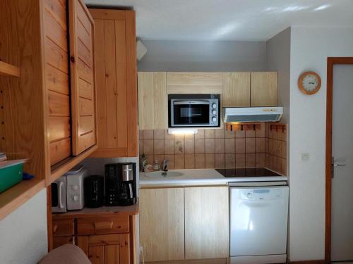 une petite cuisine avec un évier et un micro-ondes dans l'établissement Deux pièces calme proche centre Chamonix, garage, casier à ski, 4 pers. - FR-1-517-61, à Chamonix-Mont-Blanc