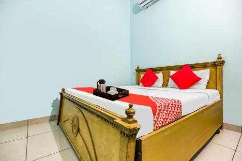 a bedroom with a bed with red pillows at Flagship Moonlight Guest House in Patiāla