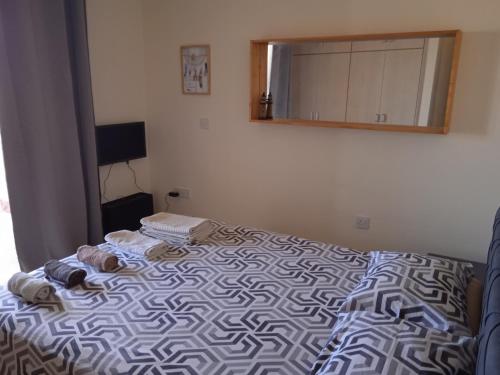 a bedroom with a bed with towels and a mirror at Xylophagou Rest and Relax 3 Ayia Napa Larnaca 1 bedroom apartment in Xylophaghou