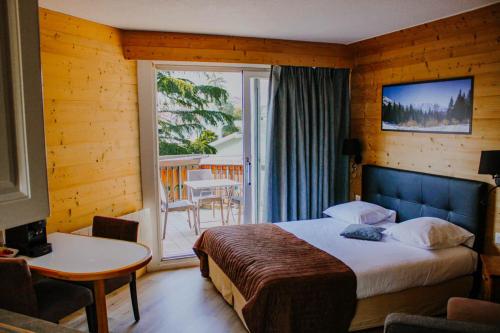 a hotel room with a bed and a balcony at Résidence Côté Chalet in Thonon-les-Bains
