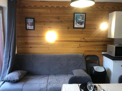 - un canapé dans une chambre dotée d'un mur en bois dans l'établissement VALMEINIER 1800, à Valmeinier