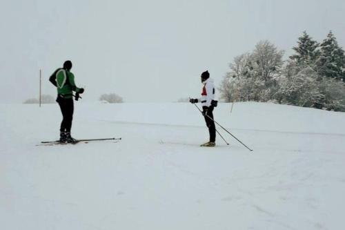 two people are on skis in the snow at Au Repos du Fayé in Grosmagny