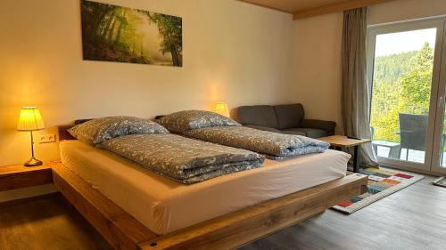a bedroom with a bed and a couch and a window at Greenhaus in Feldberg