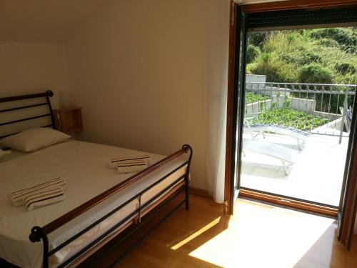 1 dormitorio con 1 cama y puerta corredera de cristal en Luxury apartment with amazing view en Mlini