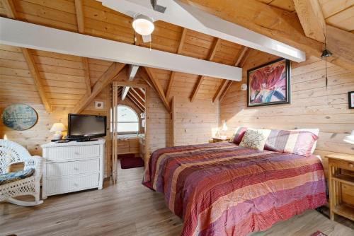 マンザニータにあるBlue Pearl MCA#278のログキャビン内のベッドルーム(ベッド1台、テレビ付)