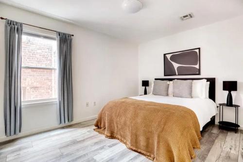 um quarto branco com uma cama e uma janela em The Loft Life 3BR in NYC! em Nova York