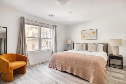 um quarto com uma cama, uma cadeira e uma janela em The Loft Life 3BR in NYC! em Nova York