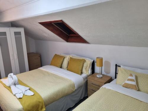 - une chambre avec 2 lits avec des draps jaunes et blancs dans l'établissement Be our Guest! Stylish-Free parking-Central location, à Headingley