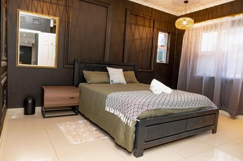 a bedroom with a bed and a mirror at Sapphire Guesthouse in Pinetown