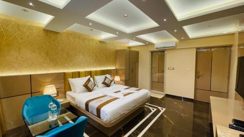 a hotel room with a bed and a blue chair at Home2 Renaissance Club in Mumbai