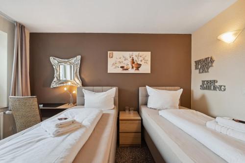 um quarto de hotel com duas camas e uma janela em 7o'Clock - Hannover Laatzen em Hanôver