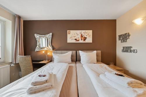 um quarto de hotel com duas camas com toalhas em 7o'Clock - Hannover Laatzen em Hanôver