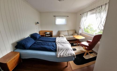 a small bedroom with a bed and a couch at Feriehus Voldstad in Syvde