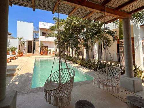 a patio with two chairs and a swimming pool at Hotelito Zicatela in Brisas de Zicatela