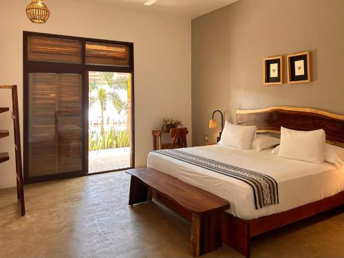 - une chambre avec un grand lit et une porte coulissante en verre dans l'établissement Hotelito Zicatela Cam a la Cruz 70938 Puerto Escondido Oax, à Brisas de Zicatela