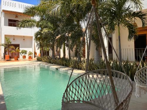 a swing in front of a house with a swimming pool at Hotelito Zicatela in Brisas de Zicatela