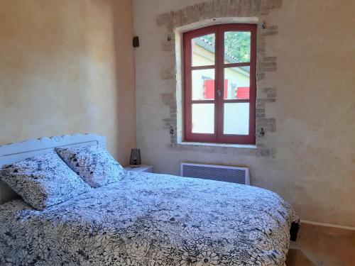 sypialnia z łóżkiem i oknem w obiekcie Gite La Minoterie - Piscine & spa 