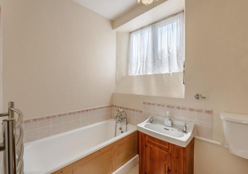 a bathroom with a bath tub and a sink at Upcott Cottage Upcott House in Barnstaple