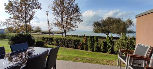a table and chairs on a patio with a view of the ocean at Panoráma Gold Wellness Apartman in Siófok