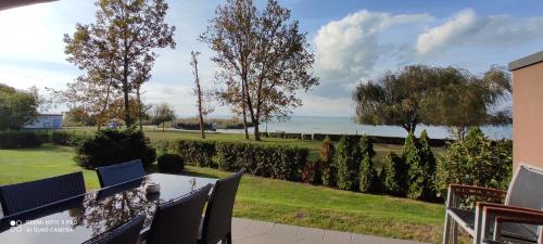a patio with a table and chairs and a view of the ocean at Panoráma Gold Wellness Apartman in Siófok