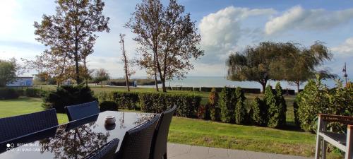 a table and chairs on a patio with a view of the ocean at Panoráma Gold Wellness Apartman in Siófok