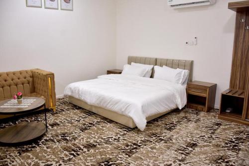a bedroom with a large white bed and a table at فندق نجران ول ان in Najran