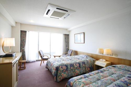 a hotel room with two beds and a window at Ibusuki Seaside Hotel in Ibusuki