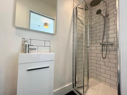 a bathroom with a sink and a shower at Spacious Home Near Seafront & Train Station 5 Bed Sleeps 10- Central Penzance in Penzance