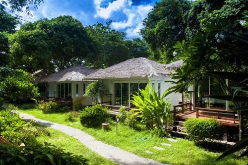 a cottage in the middle of a garden at Larissa Samed resort in Ko Samed