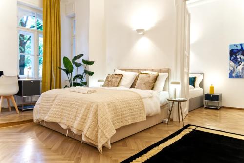 una camera bianca con un letto e una sedia di The Gallery a Monaco