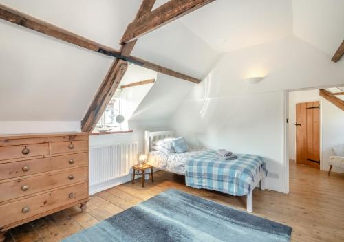 sypialnia z łóżkiem i komodą na poddaszu w obiekcie 1 Cutty Sark Cottages w mieście West Runton