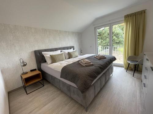 een slaapkamer met een groot bed en een raam bij ZugZuflucht-neues, modernes Ferienhaus in Freiberg