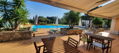 a patio with a table and chairs and a pool at Casal das Oliveiras in Setúbal