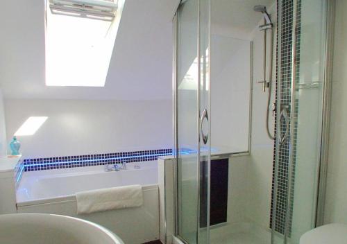 a bathroom with a shower and a tub and a sink at Harbour Lights in Torquay