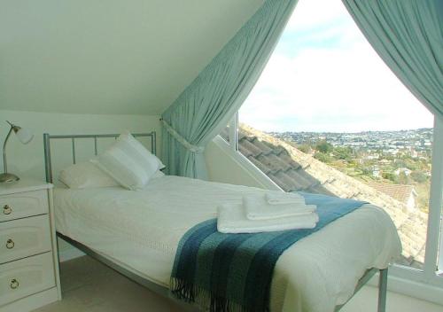 a bedroom with a bed and a window with a view at Harbour Lights in Torquay