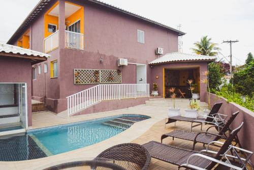 a house with a swimming pool in front of a house at Pousada Xerxes in Arraial do Cabo