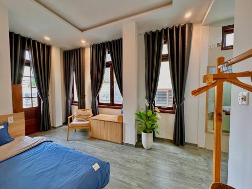 ChiPa Homestay في دا نانغ: غرفة نوم بسرير وكرسي ونوافذ
