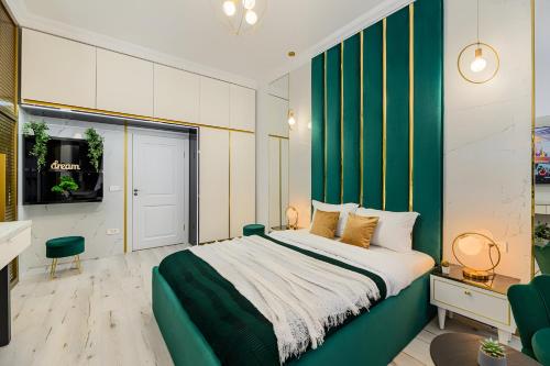 ein Schlafzimmer mit einem großen Bett und einer grünen Wand in der Unterkunft Golden Greens Studio - Mountain Scenery in Braşov