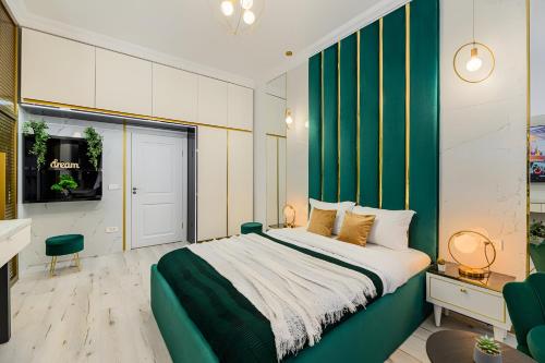 a bedroom with a large bed with a green wall at Golden Greens Studio - Luxury Design & Self Check-in in Braşov