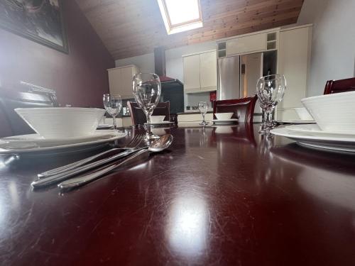 a dining room table with plates and wine glasses at Avoca Lodge in Lisburn